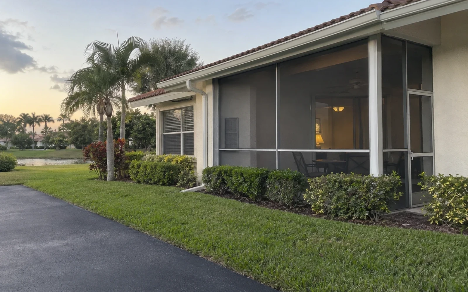 A low-rise Bonita Springs villa with a screened lanai and trimmed landscaping.
